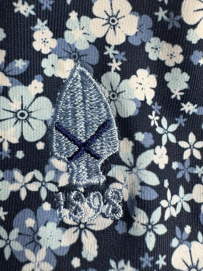 Close-up of embroidered golf emblem on 1764 Signature blue and white floral fabric